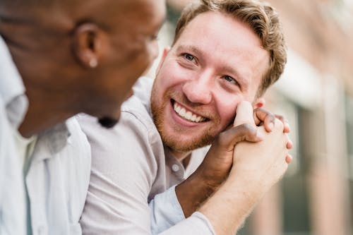 Free Happy Gay Couple Holding Hands and Looking Each Other in the Eyes  Stock Photo