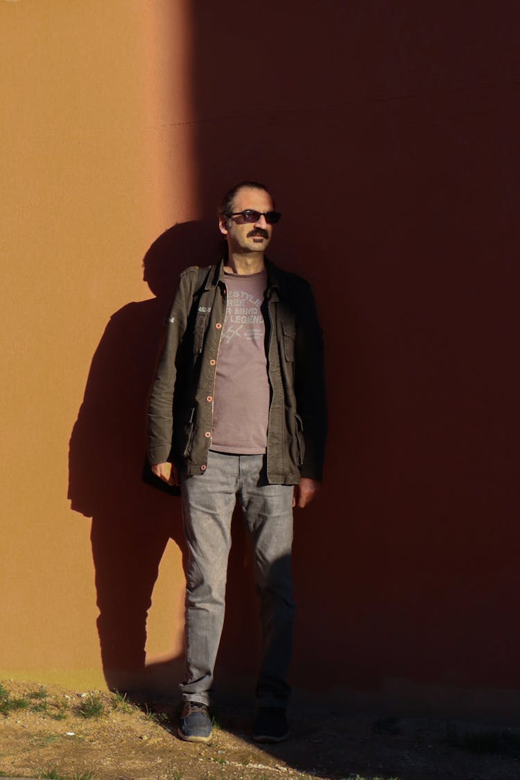 Man With Moustache In Sunglasses Posing Near Wall