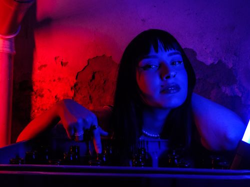 Free Emotive portrait of a woman with colorful neon lighting, creating a dramatic atmosphere. Stock Photo