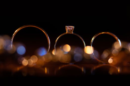 Artistic close-up of gold wedding rings with soft bokeh, symbolizing luxury and commitment.