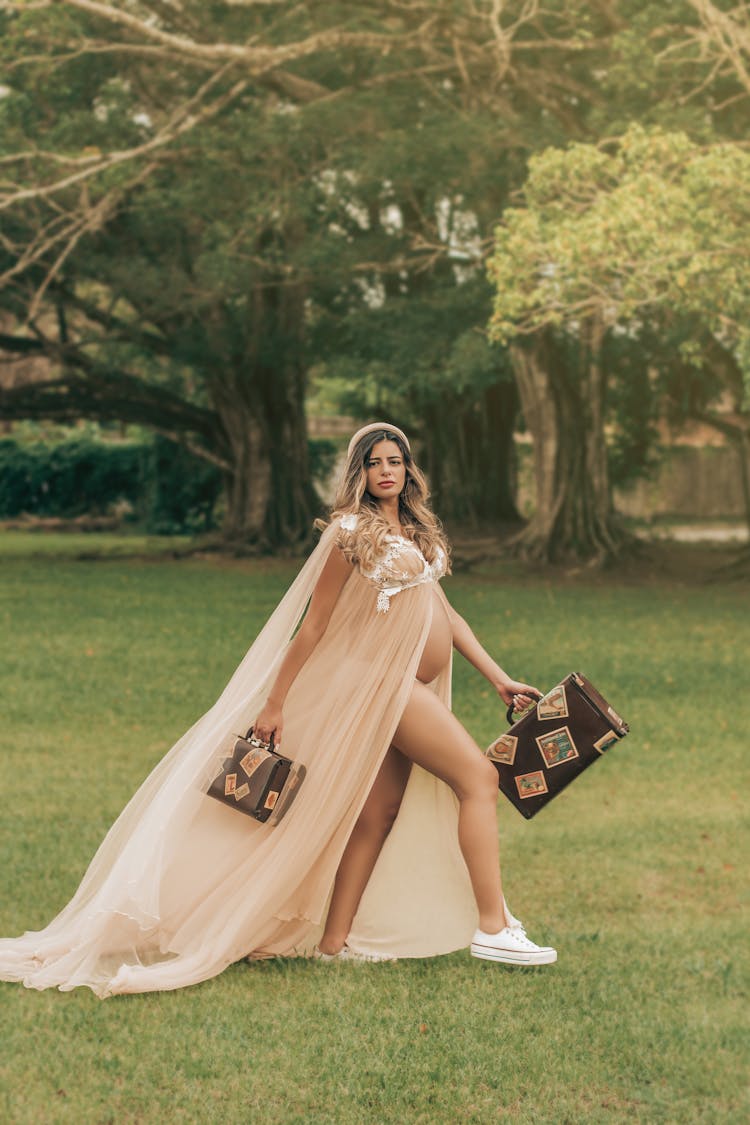 Pregnant Woman Wearing A Long Veil Outdoors On A Pregnancy Photoshoot 