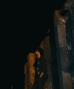 一个男人倚着石墙，仰望夜空沉思