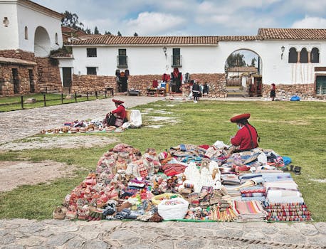 Colorful Peruvian market scene with traditional textiles and crafts displayed in a historical outdoor setting.