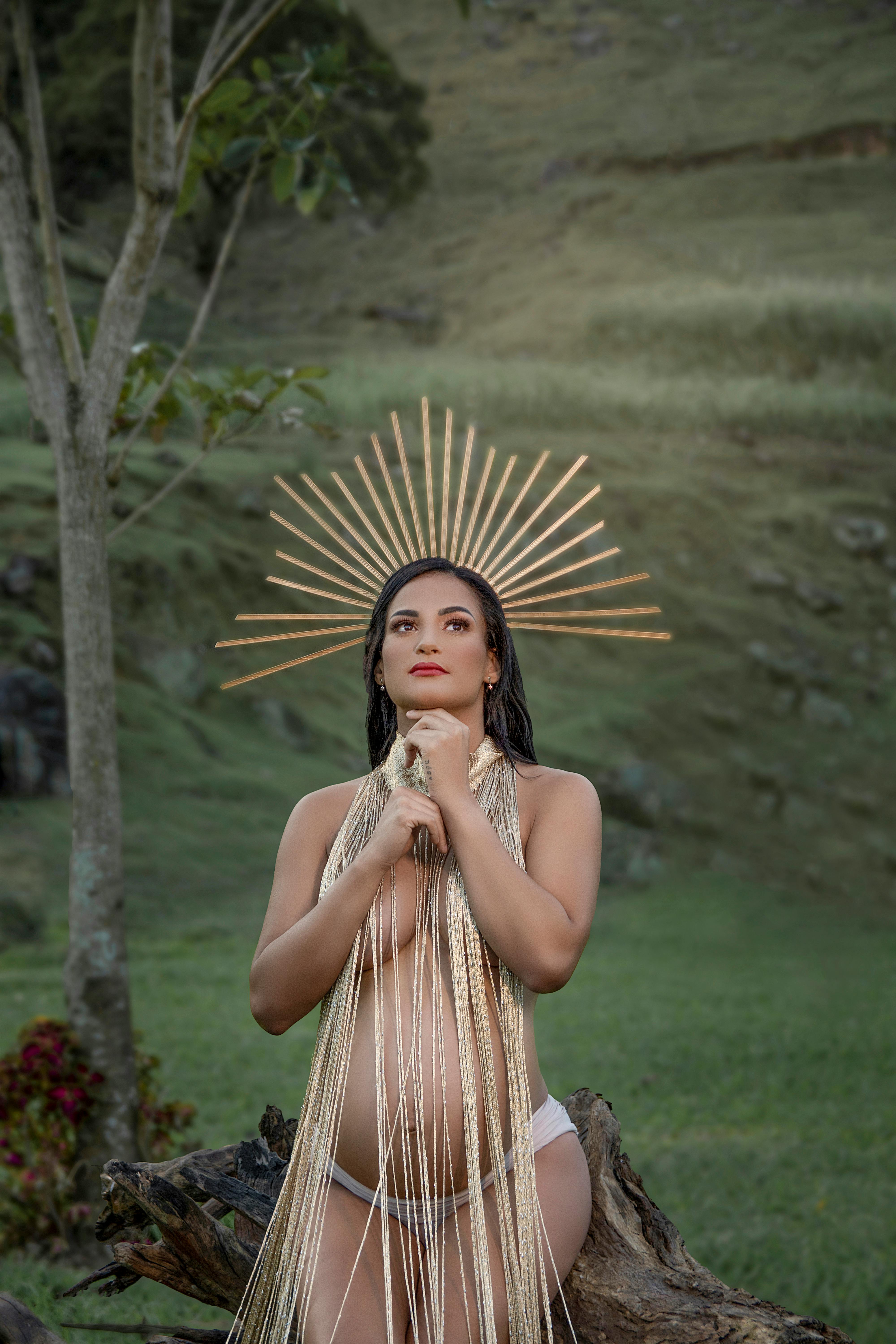 nude pregnant woman wearing a crown