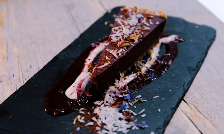 Piece Of Tasty Chocolate Cheesecake With Coconut Flakes In Cafe