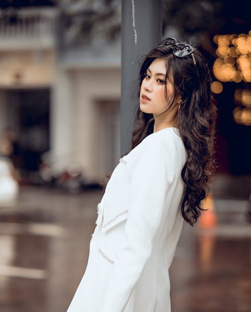 Beautiful Woman with Curly Hair Posing near Street Post