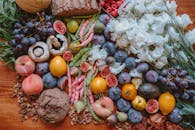 木桌上排列着色彩缤纷的新鲜水果、蔬菜、面包和鲜花