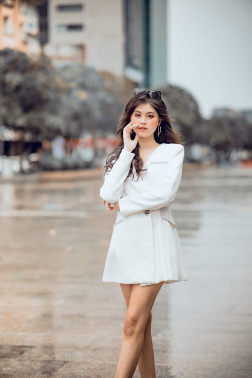 Beautiful Woman in White Dress Standing on the Street