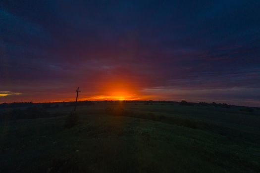 Stunning sunset over an expansive field with vibrant colors in the sky.