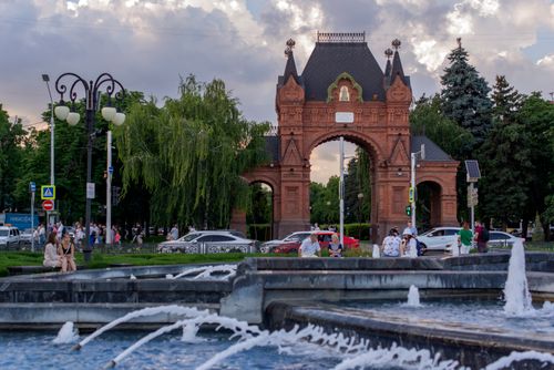 Free Triumfalnaya Arka in Krasnodar, Russia, with a bustling city scene and fountain. Stock Photo