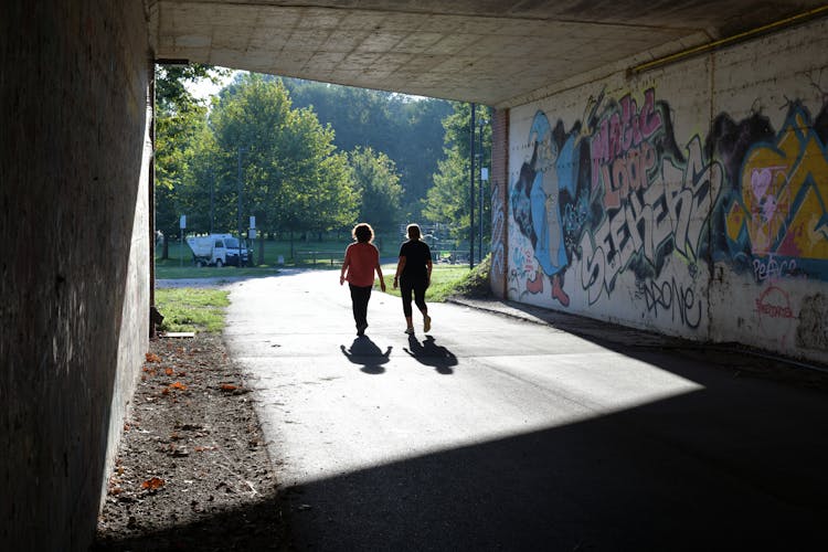 Women Walking Under A Bridge