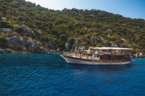 Free A luxurious cruise ship travels through stunning blue waters near a rocky island coastline. Stock Photo