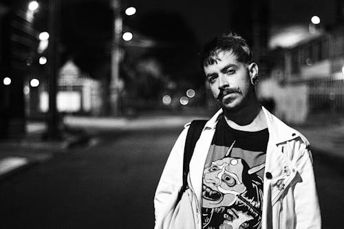 Free Black and White Photo of a Man with a Mustache Posing on the Street Stock Photo