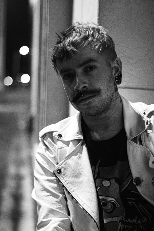 Free Stylish monochrome portrait of a man in a leather jacket with piercings. Stock Photo