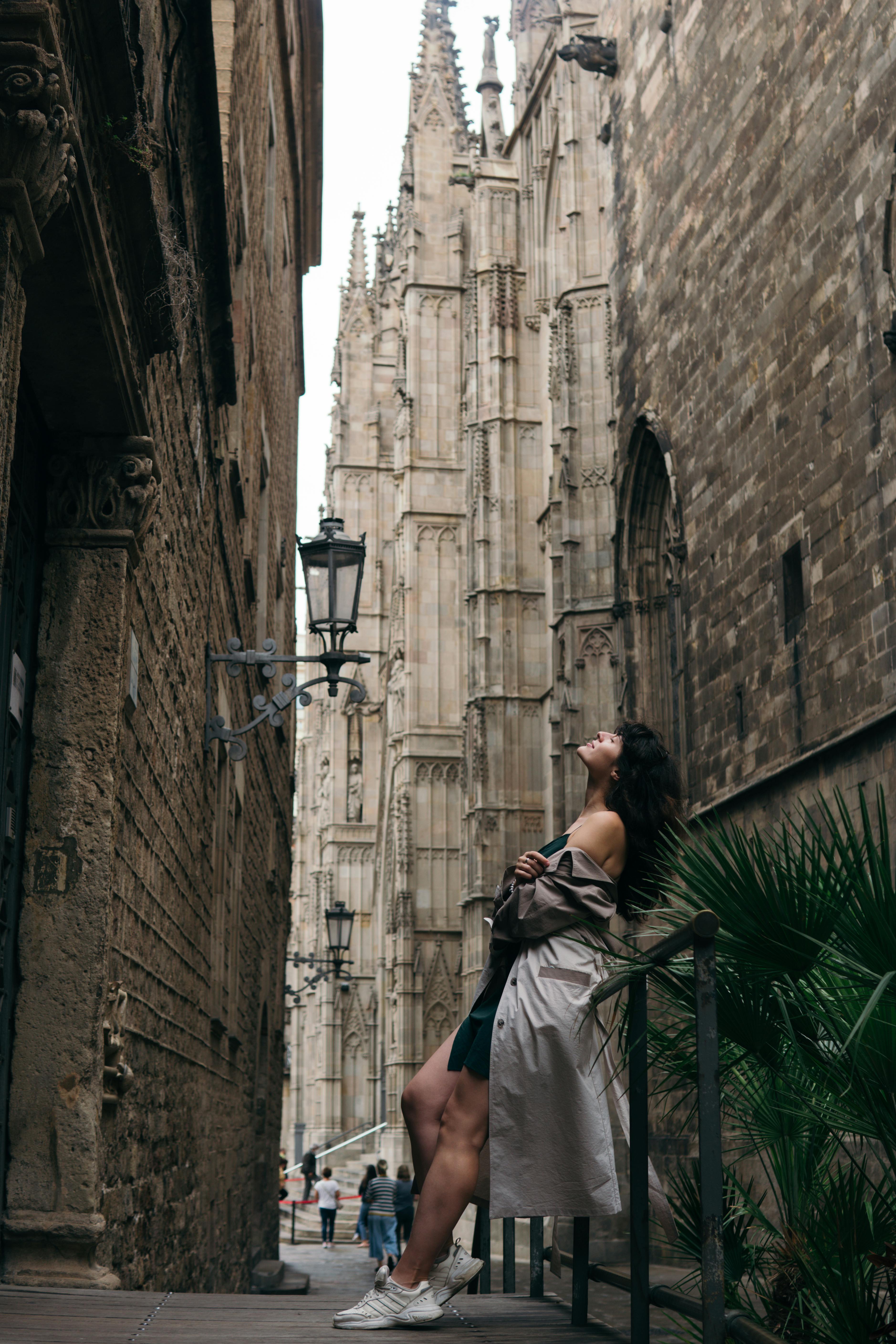 Woman Leaning on Railing in City Alley · Free Stock Photo
