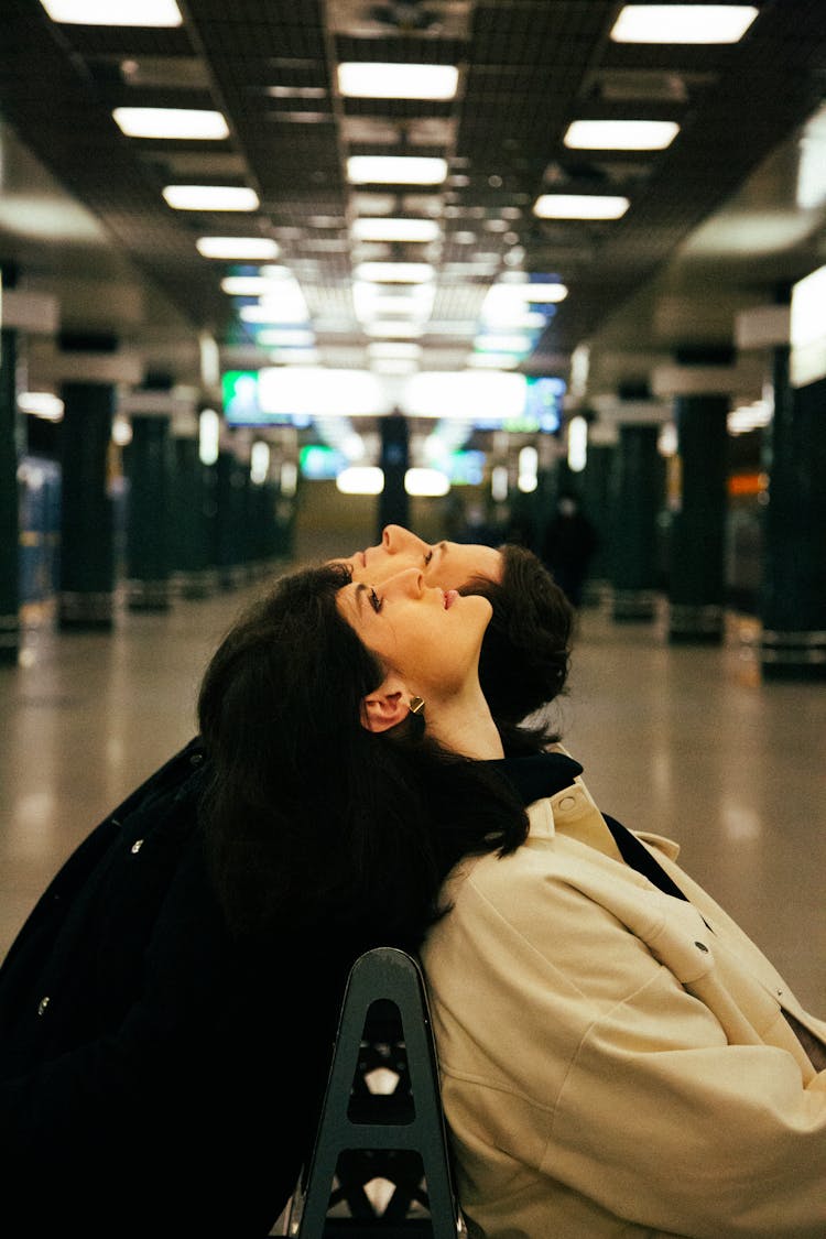 Couple Sitting On A Bench And Throwing Their Head Back