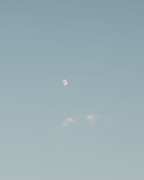 Free Stunning half-moon view in daylight against a clear blue sky with soft cloud formations. Stock Photo