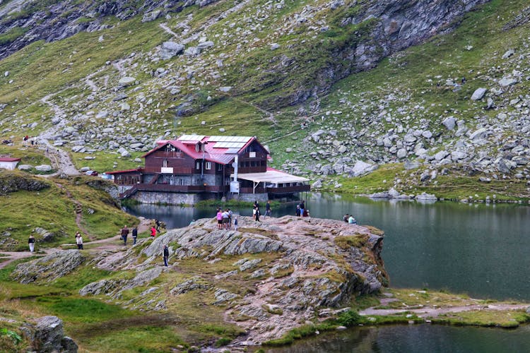 Group Of People By A House On A Lake