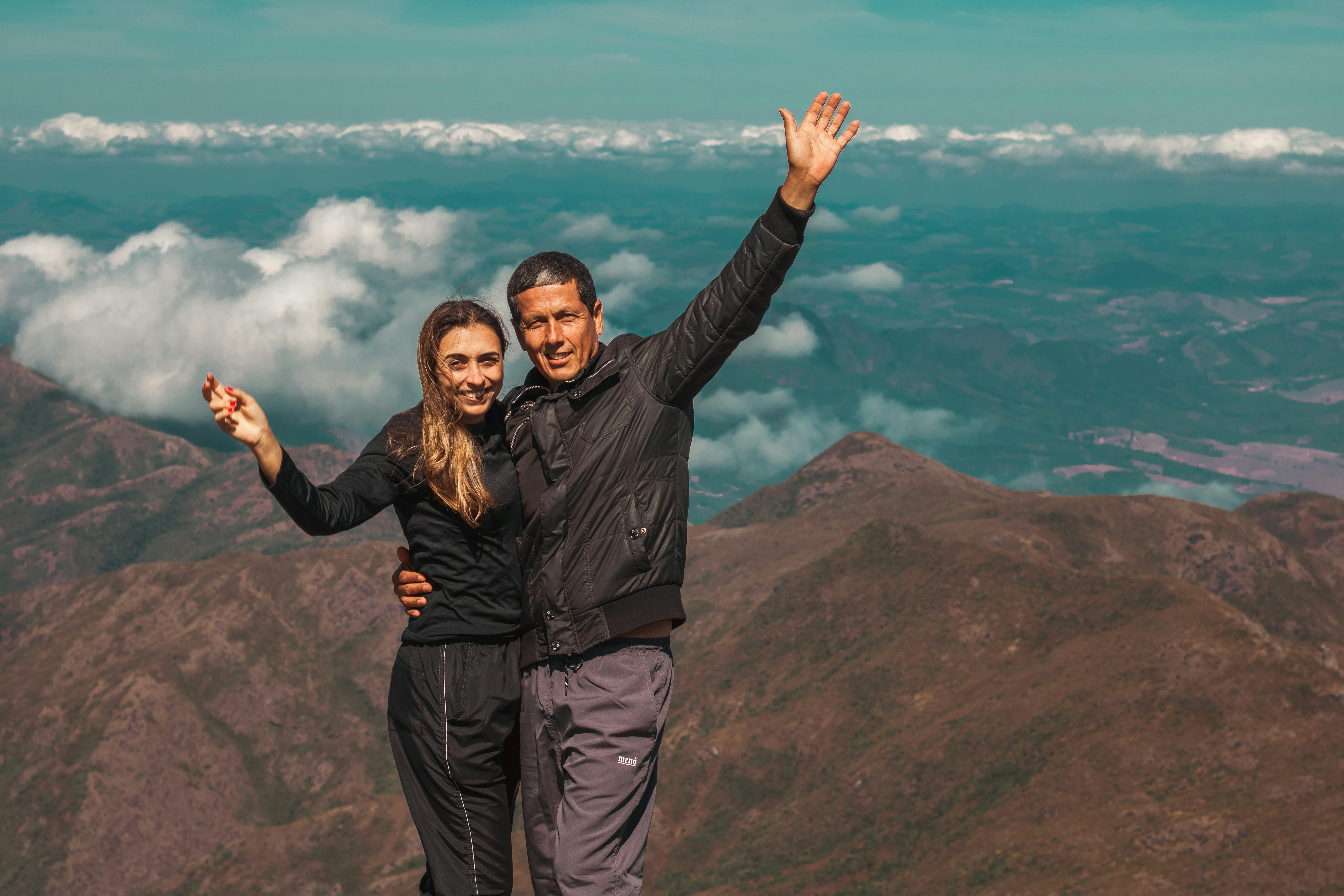 A couple enjoying a scenic mountain view, embracing adventure and capturing the moment.