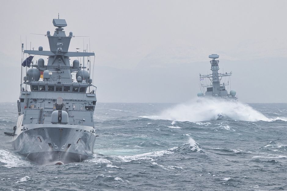 Navy warships navigating turbulent ocean waters showcasing maritime strength.