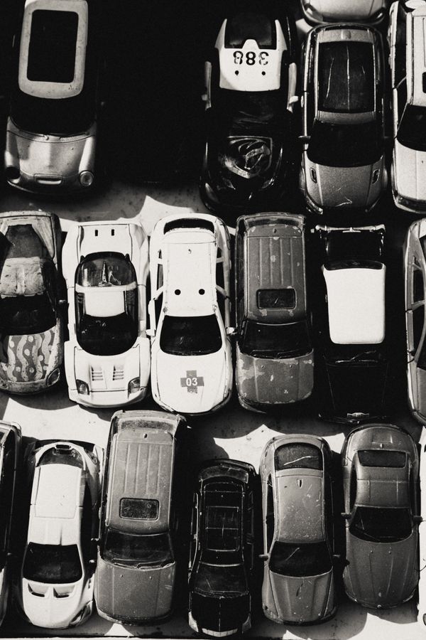 Imagem em preto e branco de vários carros de brinquedo dispostos juntos.