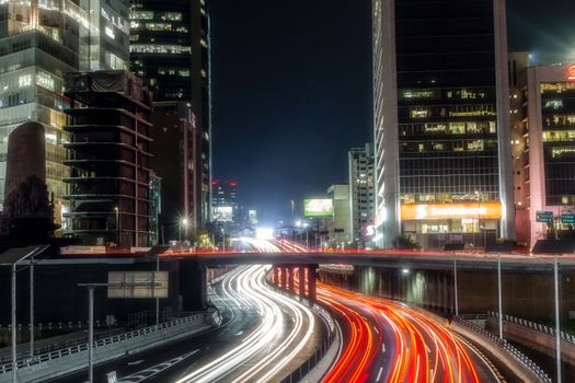 Long exposure photo capturing light trails on a busy highway in Mexico City at night.