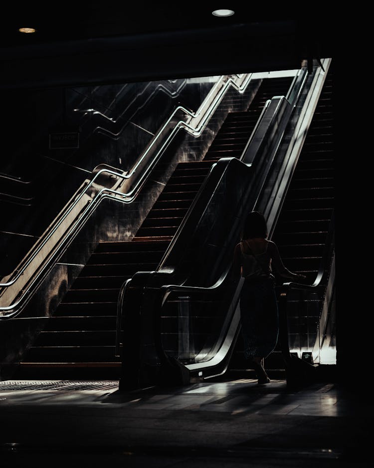 Woman Going Up With An Escalator