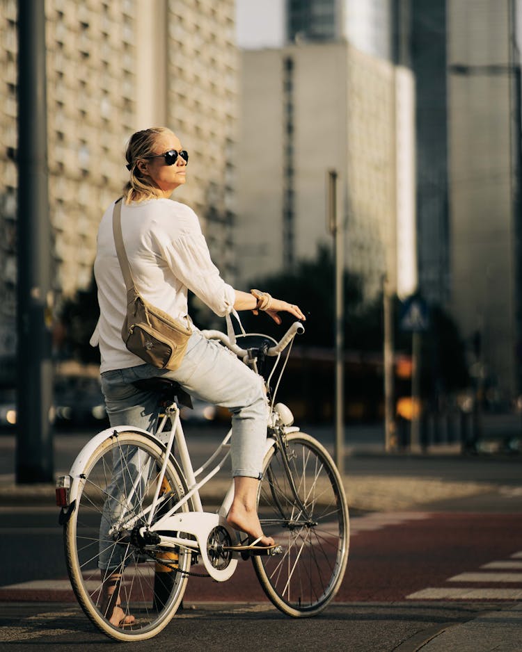 Woman In White Clothes Riding A Bike