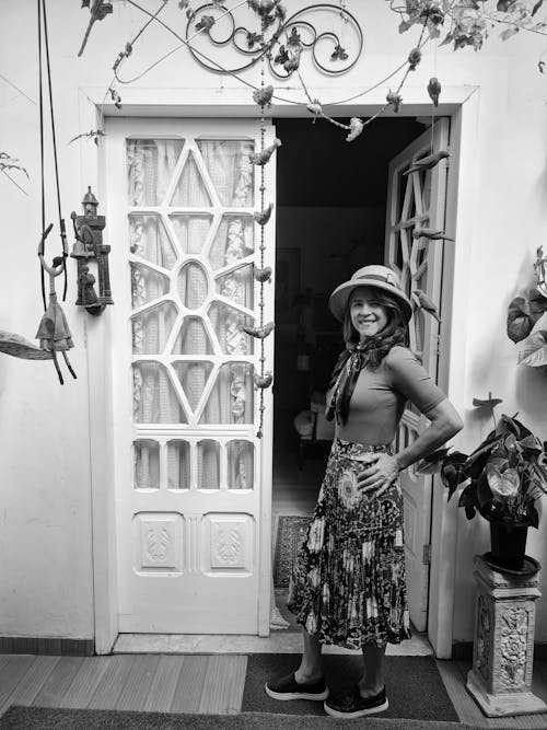 Grayscale Photo of a Beautiful Woman on the Doorway