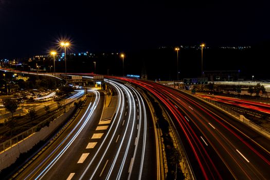 Vibrant highway light trails captured at night, showcasing dynamic urban motion.