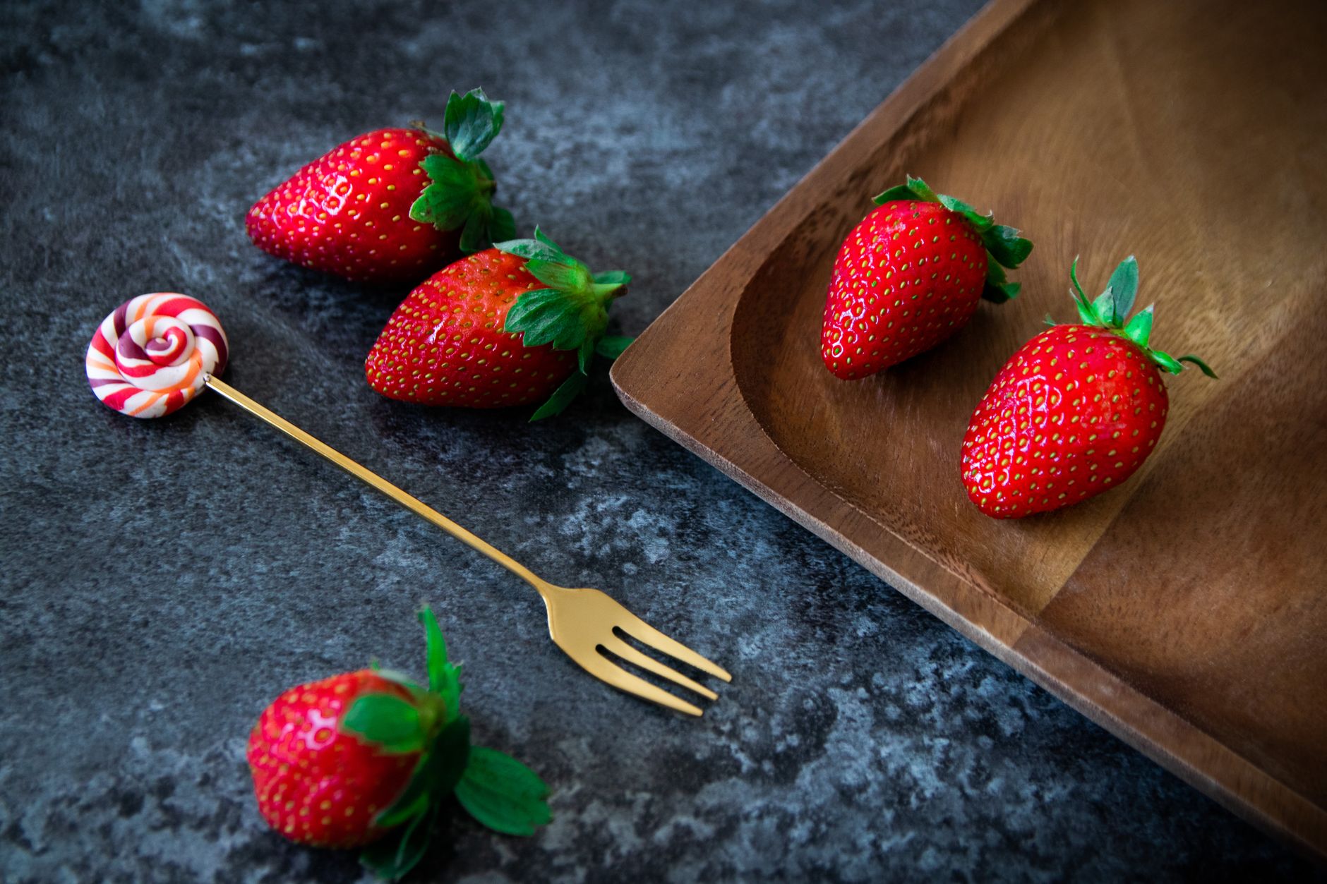Vintage strawberry candies in crinkly wrappers arranged on a wooden table
