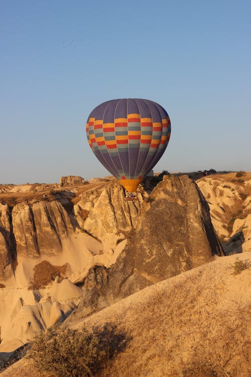 Colorful Hot Air Balloon Flying over Rock Formations