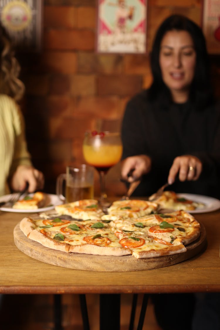 People Eating Pizza In Restaurant