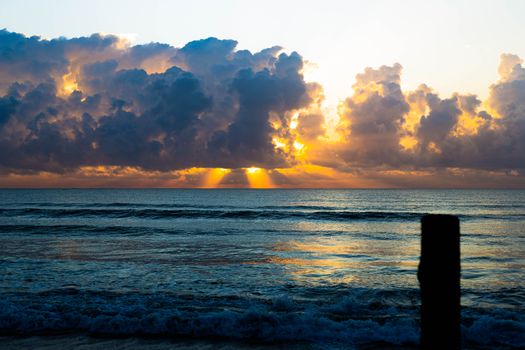 Gorgeous sunrise with vibrant sun rays over the Indian Ocean in Dar es Salaam, Tanzania.