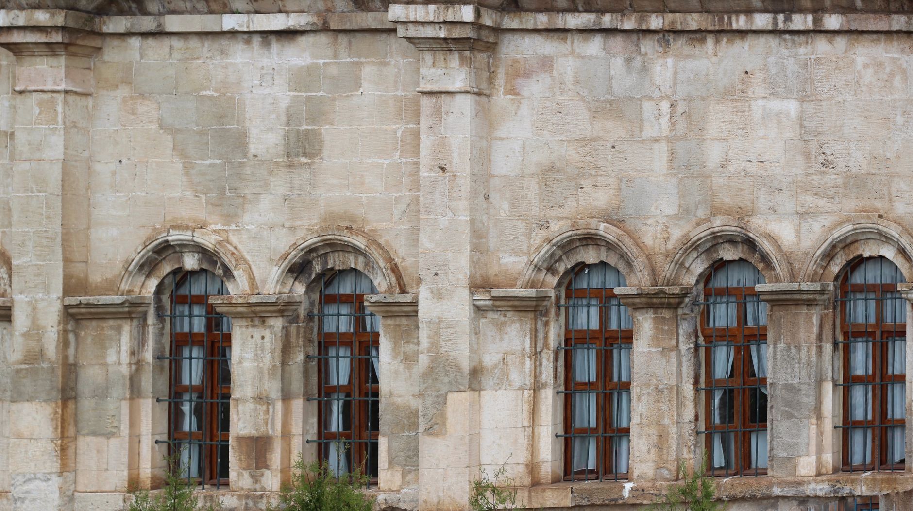 A classic architectural facade with arched windows, located in a lively urban area. — photo by Hatice Esma DEMİREL / Pexels