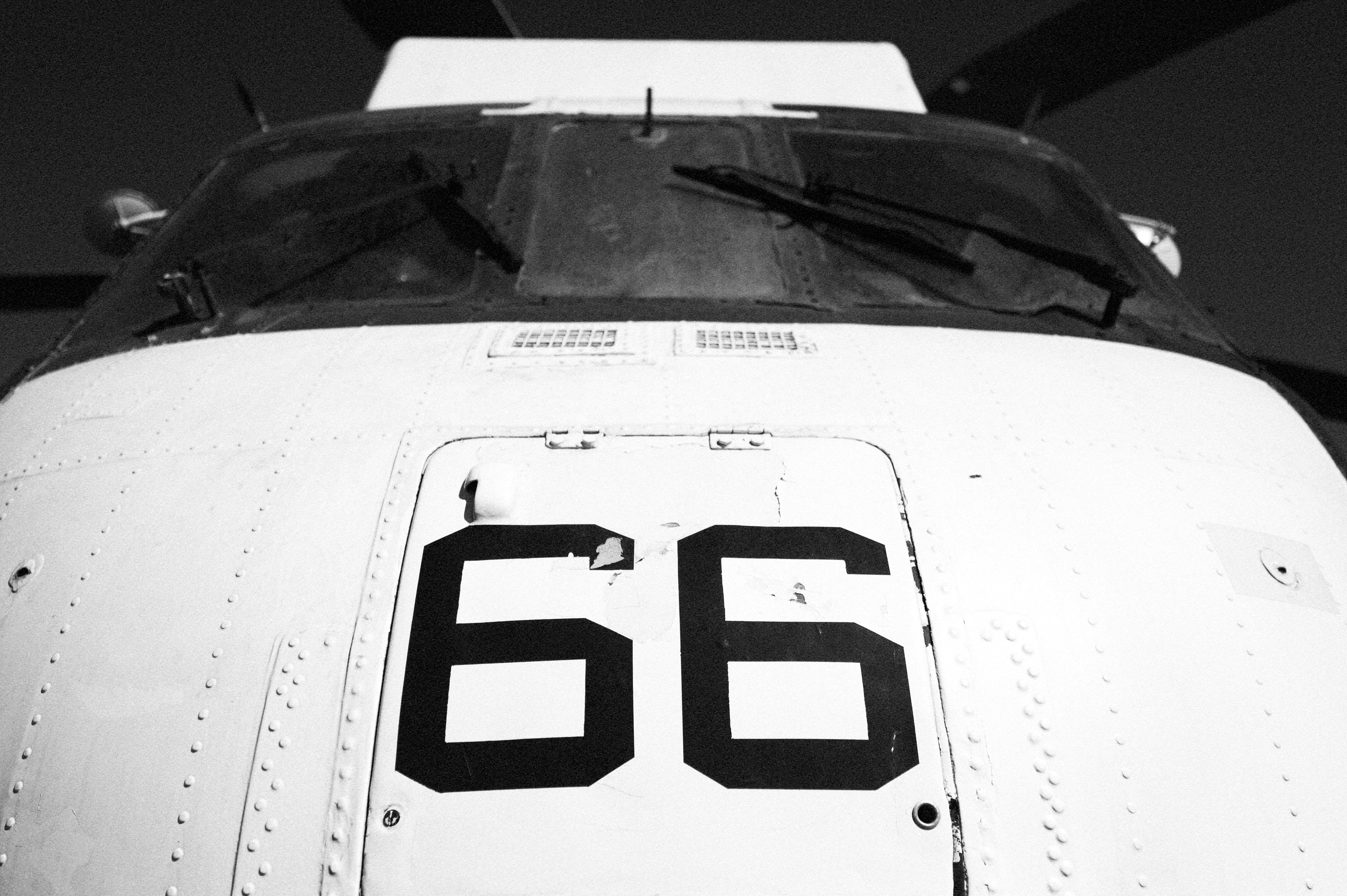 Black and white photo of a vintage military aircraft featuring the number 66 on its nose, San Diego.