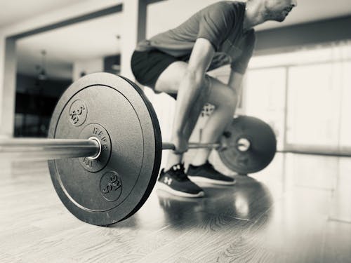 Monochrome Photo of Man doing Weightlifting 