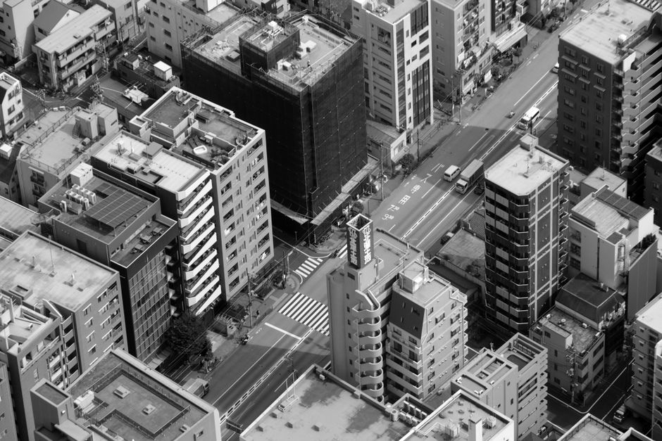 High-angle view of Tokyo's urban architecture in monochrome, showcasing skyscrapers and bustling streets.
