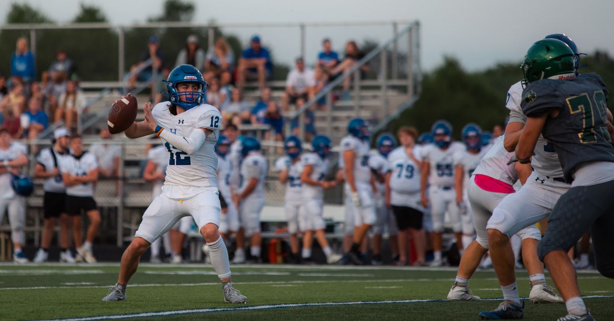 Young quarterback throwing a deep pass under pressure