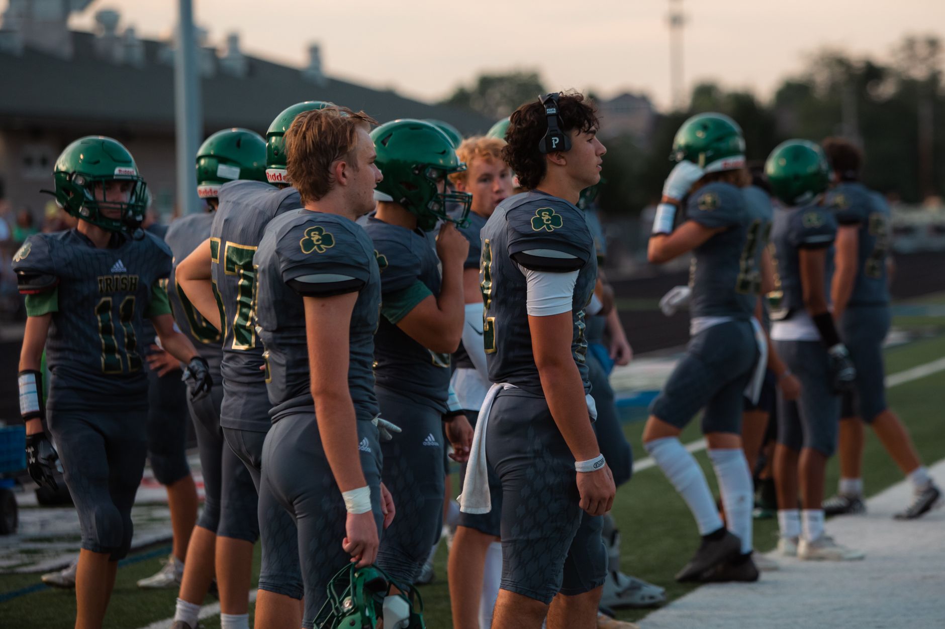 football players waiting during VAR review near penalty area, crowd frozen in suspense