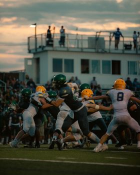 Players in action during a sunset football game, showcasing teamwork and strategy.