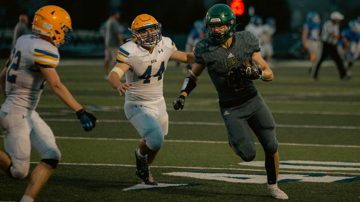High school football players under stadium lights