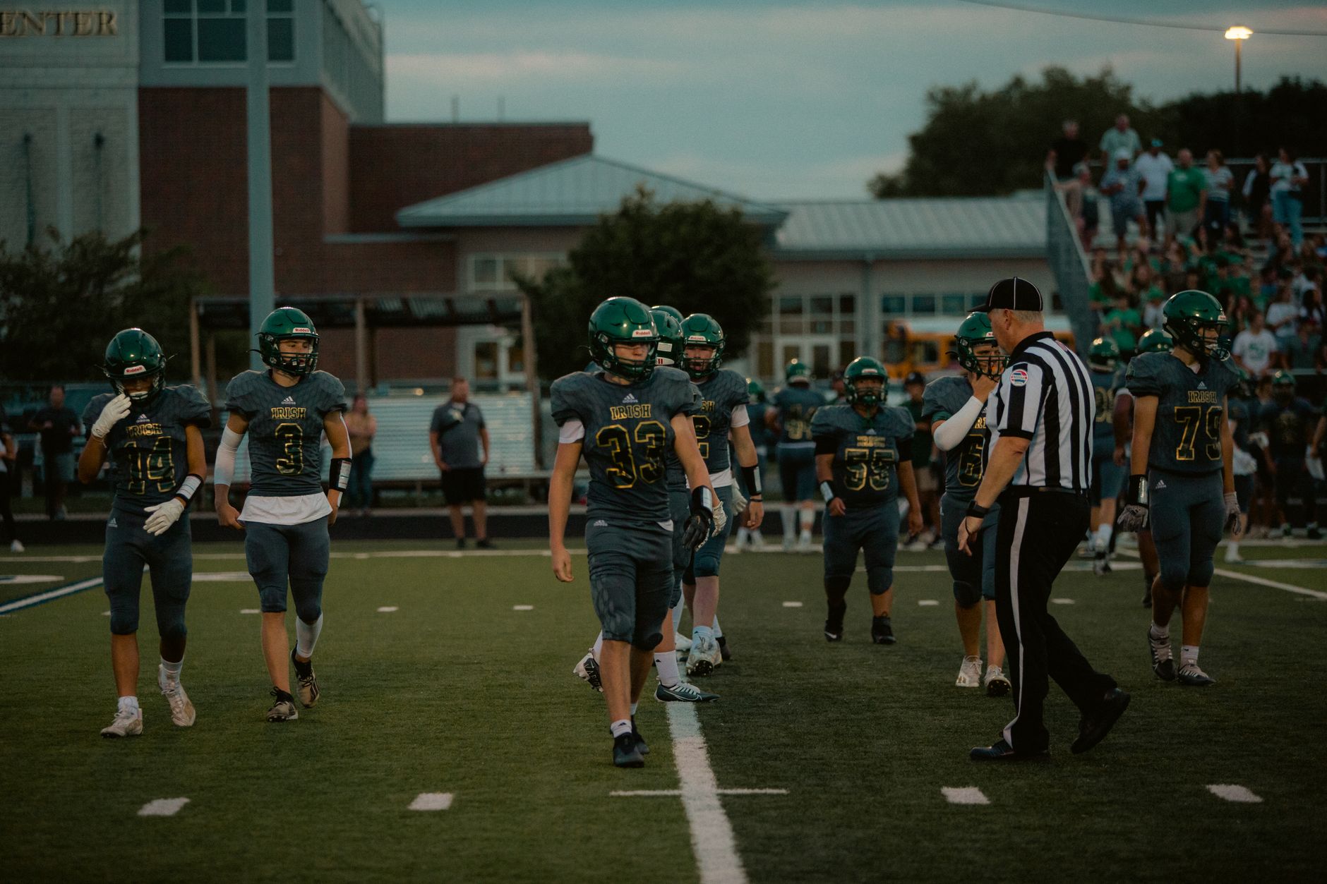 high school football equipment inspection with coach checking mouthguards wrist cards and arm sleeves