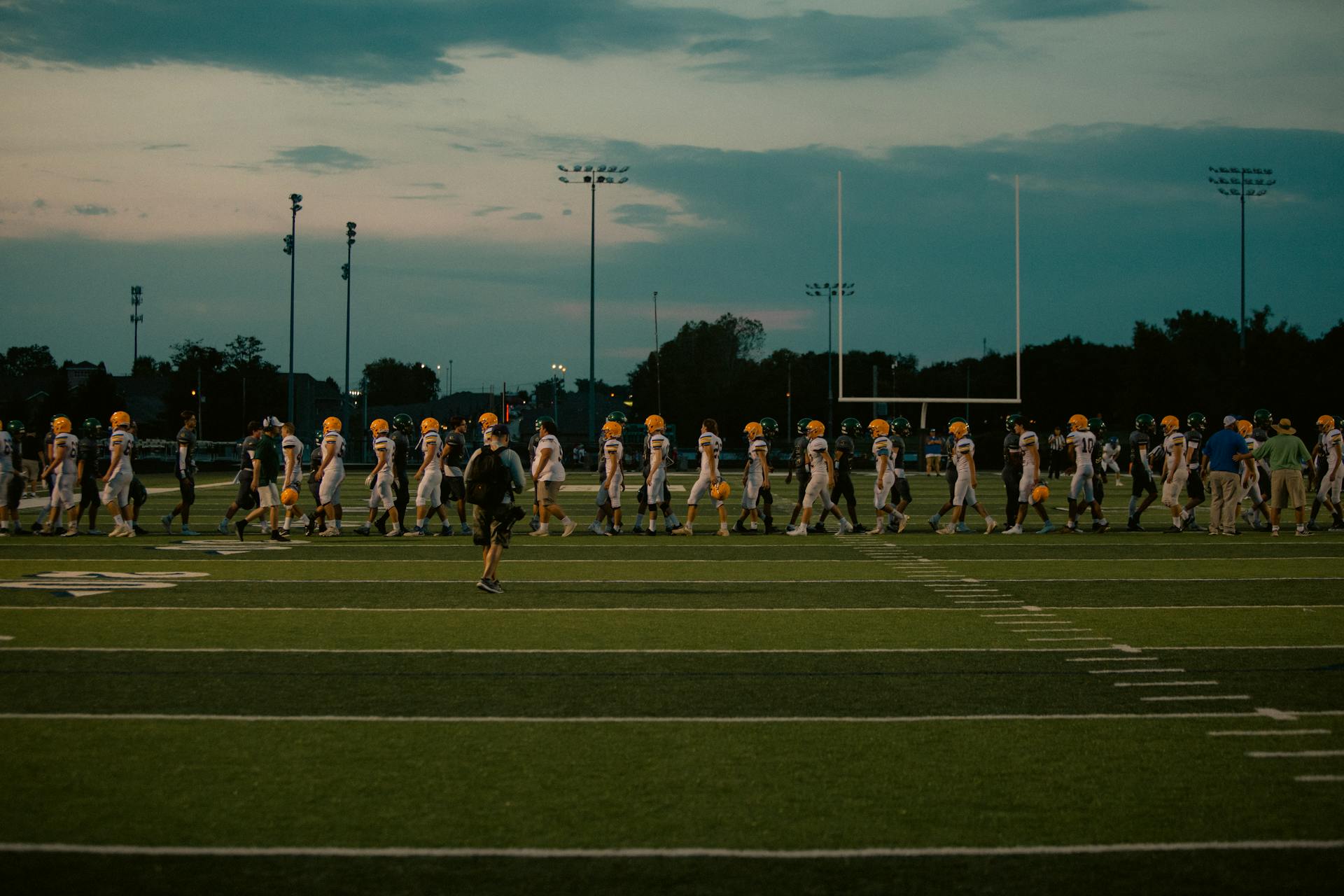 American Football Players on Field at Dusk