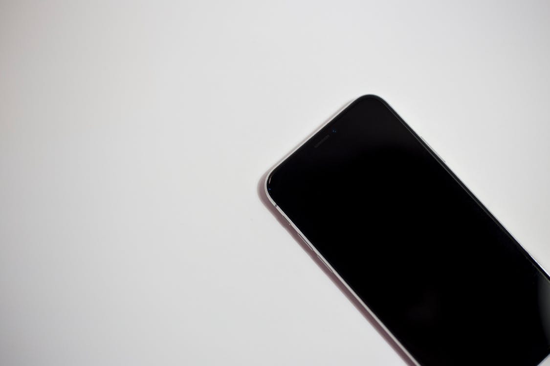 Kostenlos Schwarzes Smartphone Auf Weißer Oberfläche Ausgeschaltet Stock-Foto