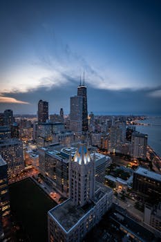 A breathtaking aerial shot of Chicago's skyline, featuring iconic skyscrapers at twilight, with views of Lake Michigan.
