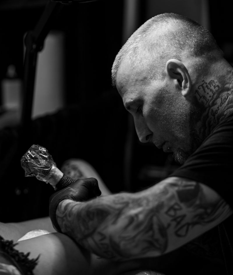 Tatuador trabalhando em blackwork no braço