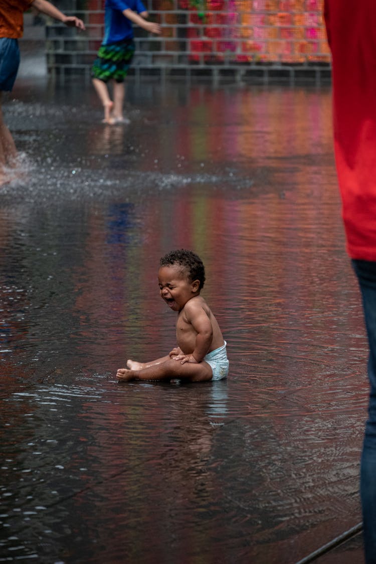 Crying Toddler Sitting On The Ground 