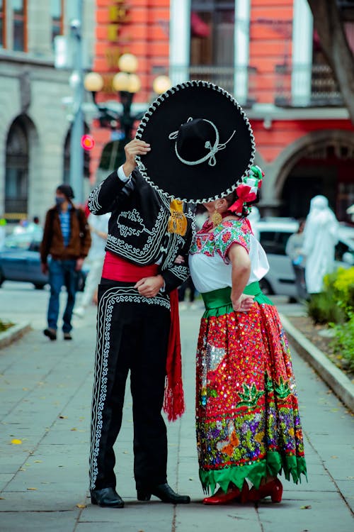 Kissing Couple Covering Faces with a Black Sombrero