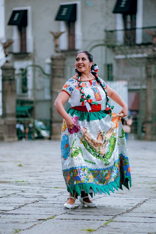 Free A woman in colorful traditional Mexican attire dances in Heroica Puebla de Zaragoza, México. Stock Photo